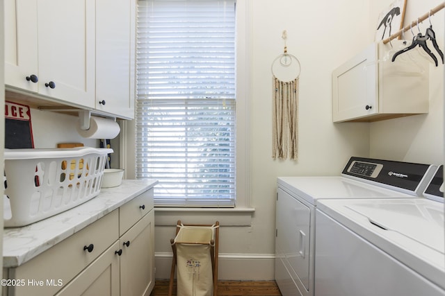 laundry room with washing machine and dryer, cabinet space, and baseboards