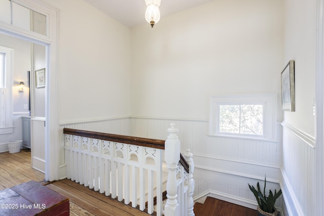 staircase featuring wainscoting and wood finished floors