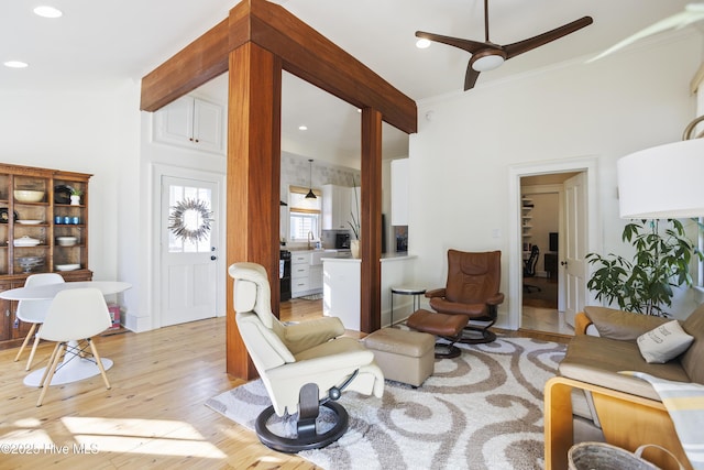 living area featuring light wood-style flooring, ornamental molding, a ceiling fan, and recessed lighting