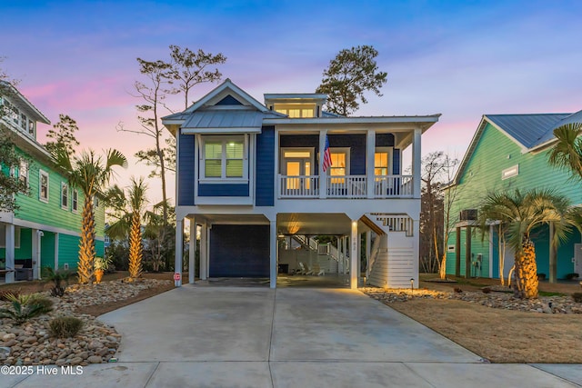 coastal home with a garage, a carport, and a porch