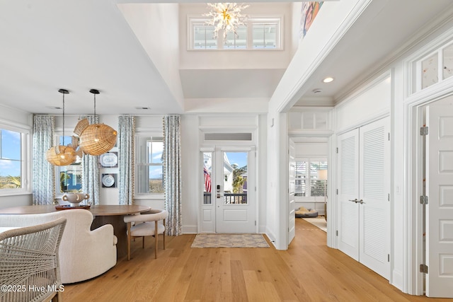 entrance foyer with light hardwood / wood-style flooring, a chandelier, plenty of natural light, and breakfast area