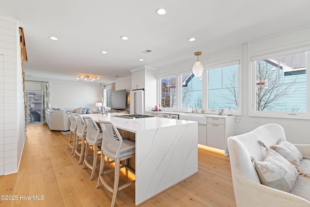 kitchen with white cabinets, pendant lighting, plenty of natural light, and a kitchen island