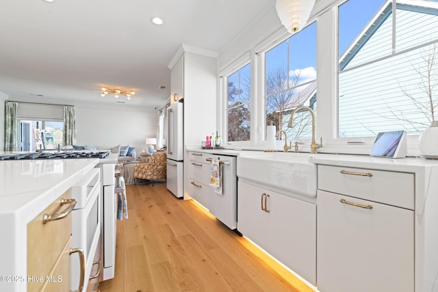 kitchen with white cabinets, gas stove, and stainless steel dishwasher