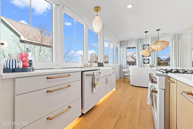 kitchen featuring hanging light fixtures, white cabinetry, dishwasher, and range with gas cooktop