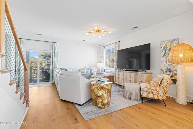 living room featuring light wood-type flooring, a wealth of natural light, and ornamental molding