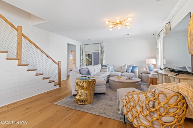 living room featuring ornamental molding, hardwood / wood-style floors, and a chandelier