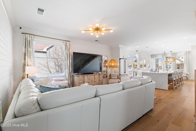 living room featuring crown molding and light hardwood / wood-style floors