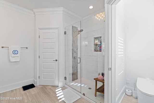 bathroom with ornamental molding, a shower with door, and toilet