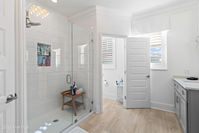 bathroom with ornamental molding, vanity, and a shower with door