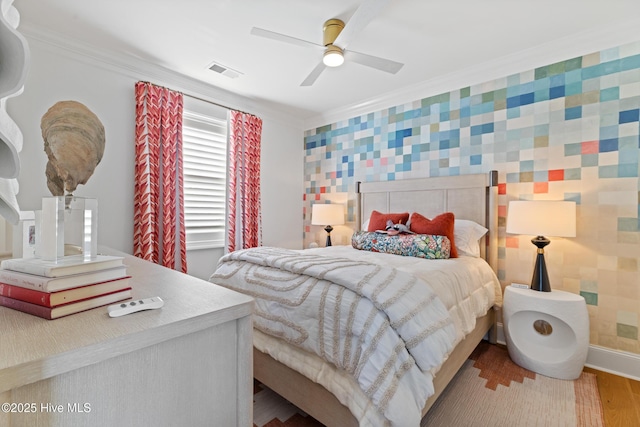 bedroom with hardwood / wood-style flooring, ceiling fan, and crown molding