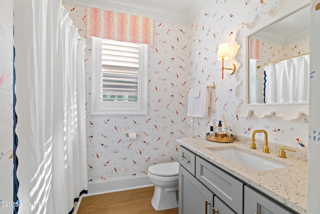 bathroom with ornamental molding, hardwood / wood-style flooring, toilet, and vanity