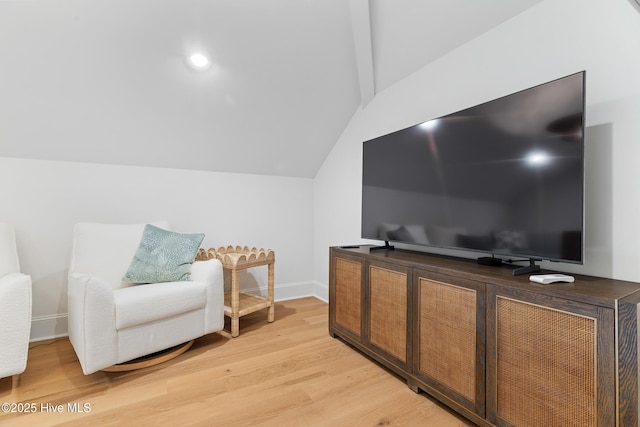 living area featuring lofted ceiling and light hardwood / wood-style floors