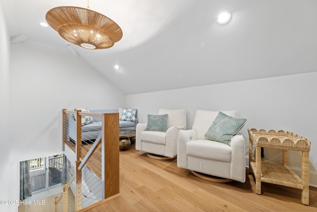 sitting room with hardwood / wood-style floors, lofted ceiling, and a notable chandelier