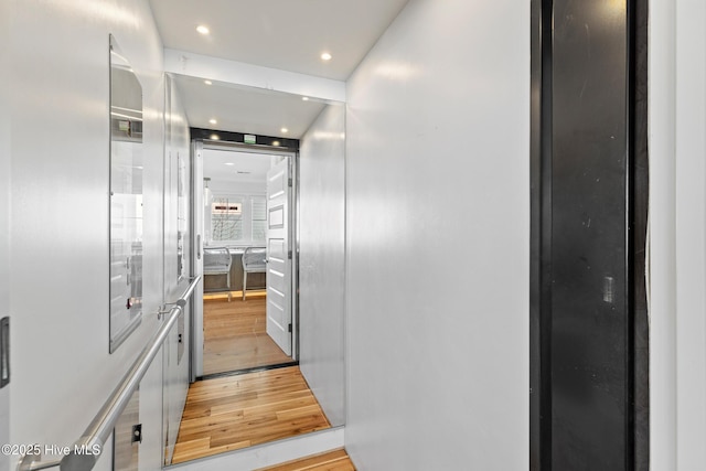 corridor with light hardwood / wood-style flooring