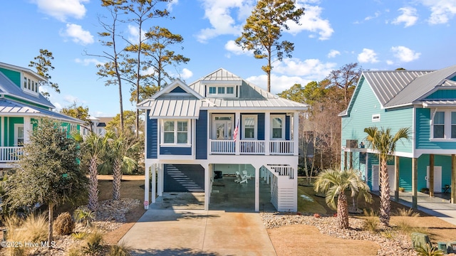 raised beach house featuring a carport and a porch