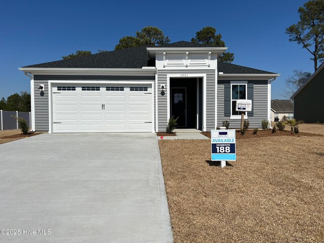 view of front of property featuring a garage and a front lawn