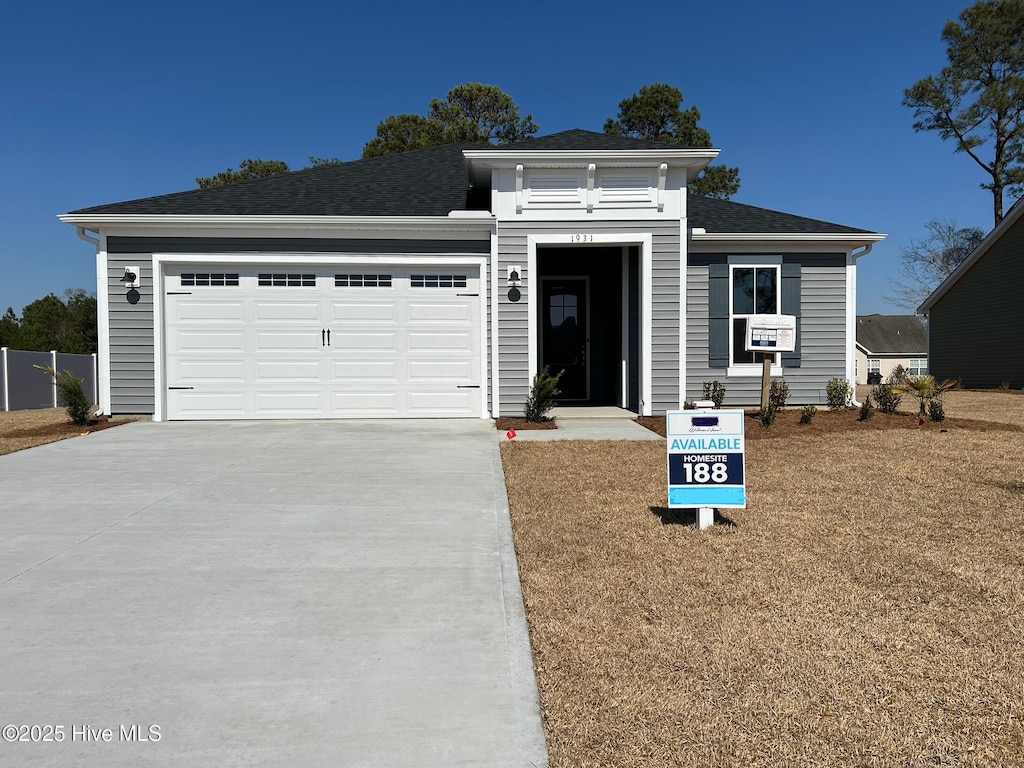 view of front of home with an attached garage, driveway, and roof with shingles