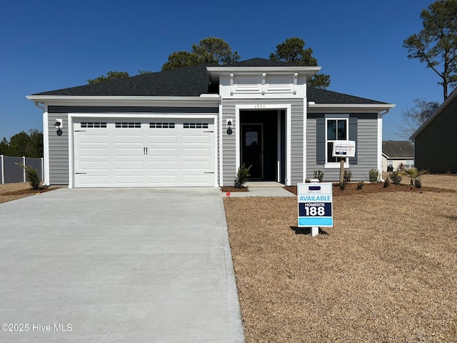 view of front of home with an attached garage, driveway, and roof with shingles