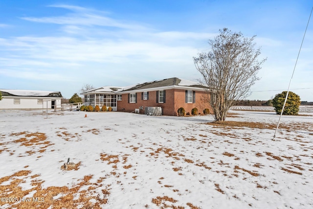 snow covered property featuring a sunroom