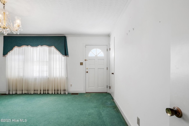 entryway featuring ornamental molding, carpet, a textured ceiling, and a chandelier