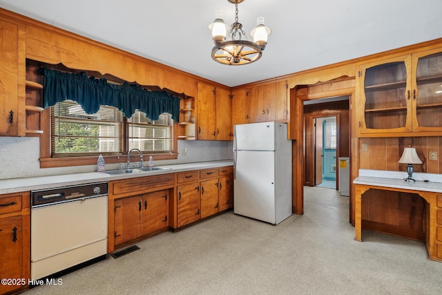 kitchen with white appliances, a chandelier, sink, and hanging light fixtures