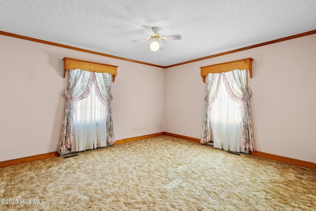 carpeted empty room with ceiling fan, ornamental molding, and a textured ceiling