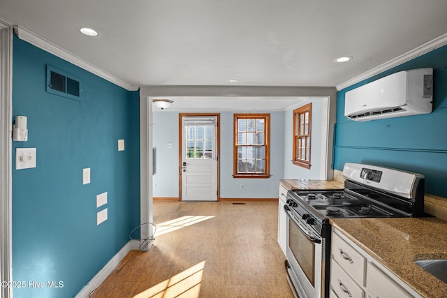 kitchen with white cabinetry, stainless steel range with gas cooktop, crown molding, and a wall unit AC