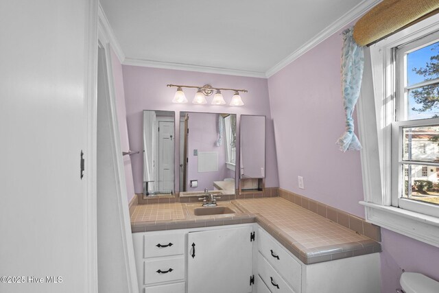 bathroom featuring crown molding, a tile shower, and toilet