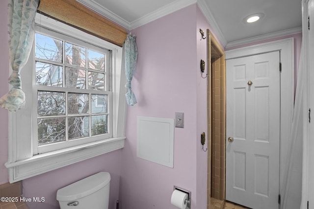 bathroom featuring ornamental molding, toilet, and a healthy amount of sunlight