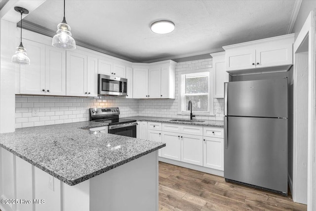 kitchen featuring stainless steel appliances, sink, white cabinets, and kitchen peninsula