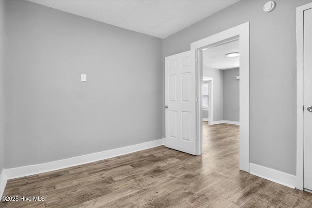 empty room featuring wood-type flooring and a textured ceiling