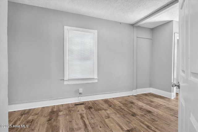 spare room with wood-type flooring and a textured ceiling