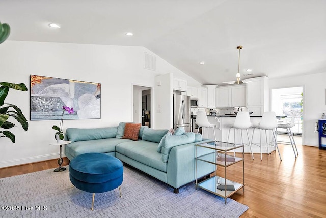 living area with light wood finished floors, visible vents, baseboards, vaulted ceiling, and recessed lighting