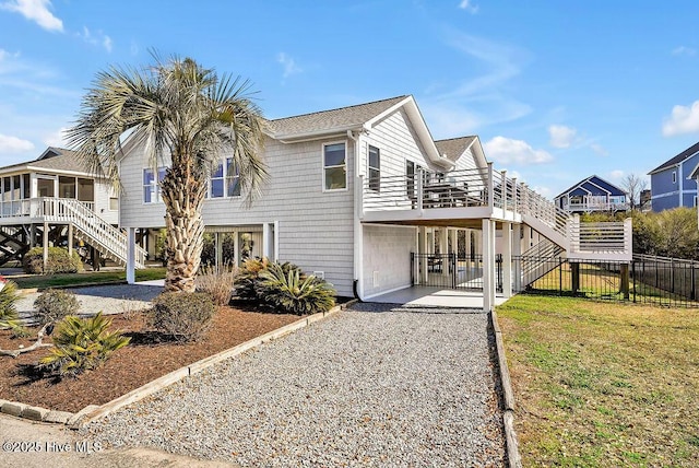 view of home's exterior featuring a gate, stairway, driveway, and fence