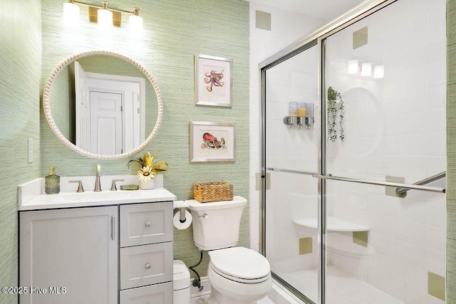 bathroom with a shower stall, toilet, and vanity