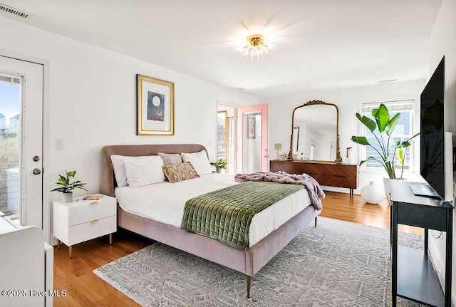 bedroom featuring visible vents and wood finished floors