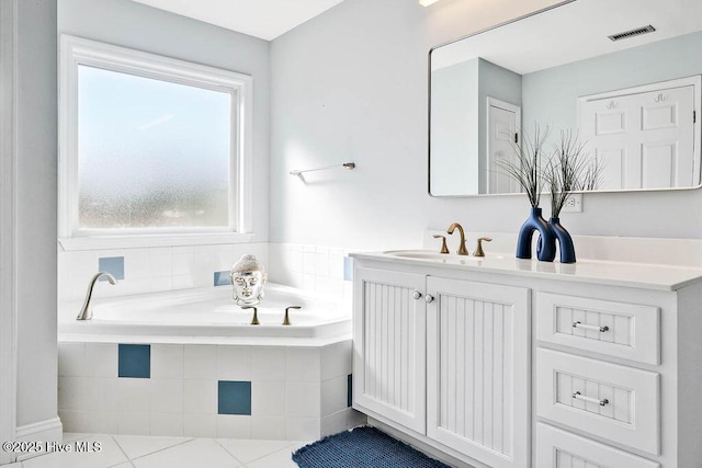 full bath featuring tile patterned floors, visible vents, a garden tub, and vanity