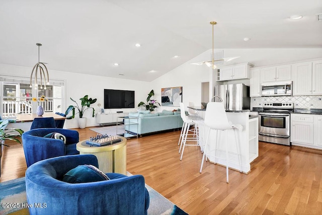 living area featuring visible vents, recessed lighting, ceiling fan, vaulted ceiling, and light wood-style floors