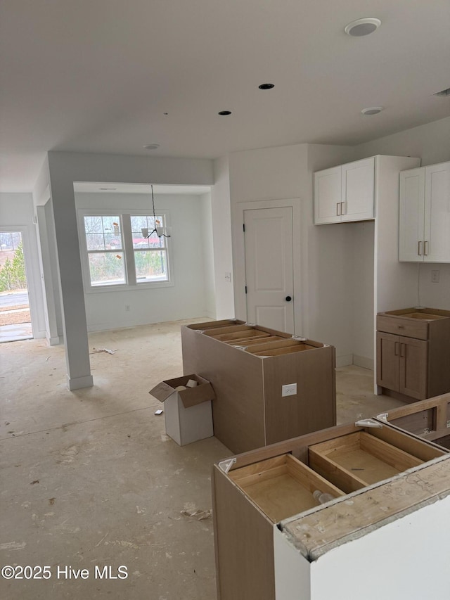 kitchen featuring a kitchen island, a healthy amount of sunlight, and white cabinets