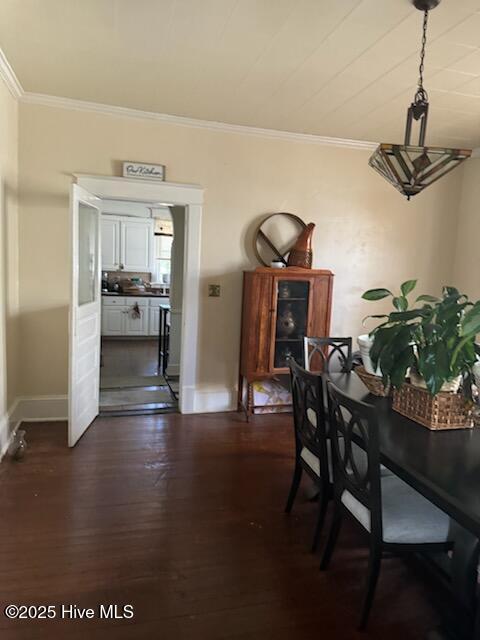 dining area with baseboards, ornamental molding, and dark wood-style flooring