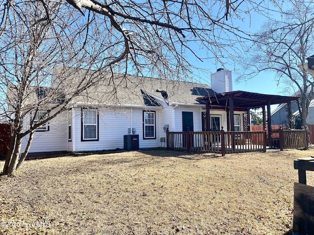 rear view of house with a lawn, central air condition unit, and a pergola