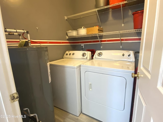 laundry area featuring independent washer and dryer, light hardwood / wood-style flooring, and water heater