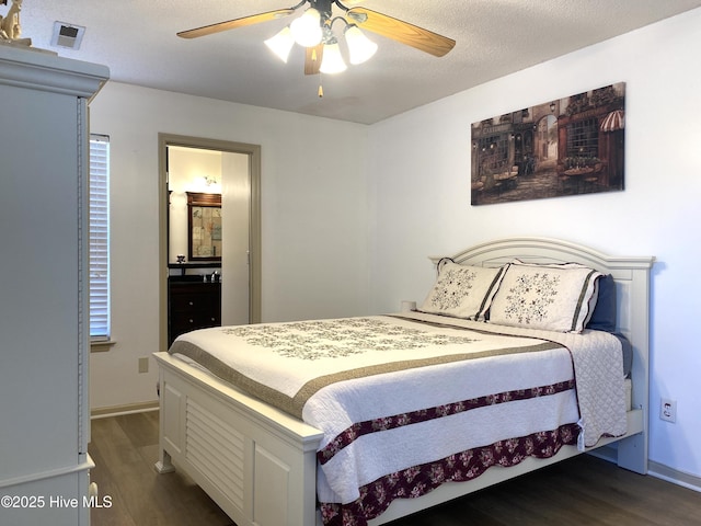 bedroom with a textured ceiling, dark hardwood / wood-style floors, and ceiling fan