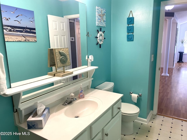 bathroom featuring vanity, decorative columns, and toilet