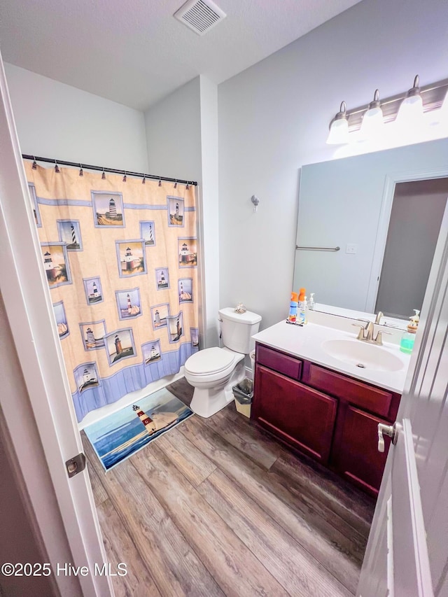 bathroom featuring vanity, hardwood / wood-style flooring, toilet, and a shower with shower curtain