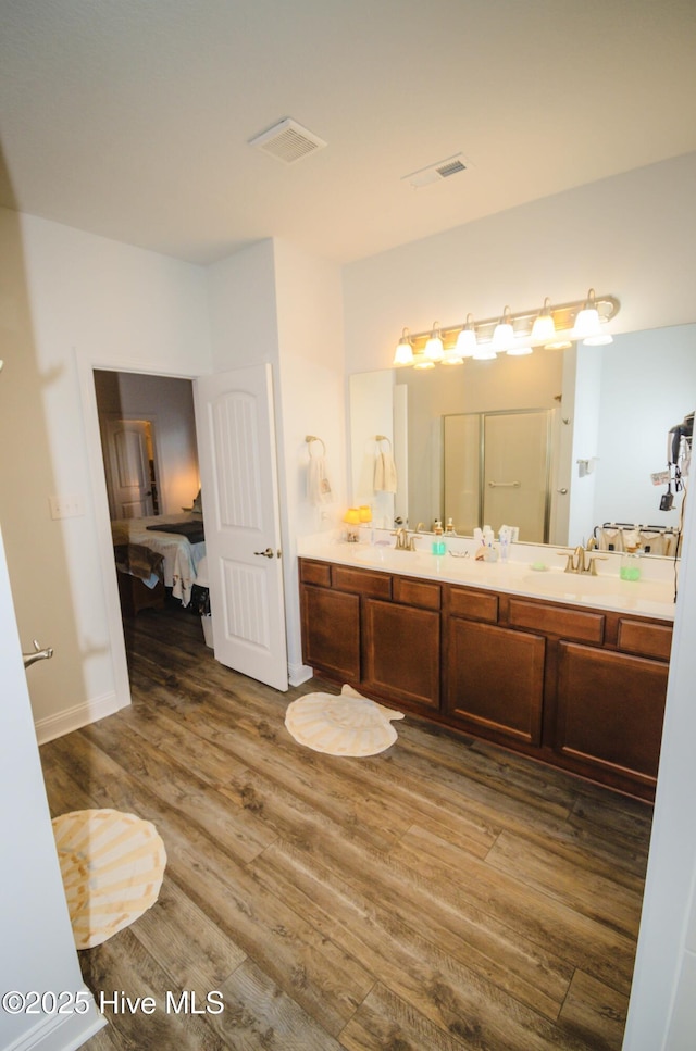 bathroom featuring vanity, an enclosed shower, and hardwood / wood-style flooring