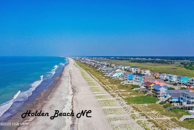 birds eye view of property with a water view and a beach view