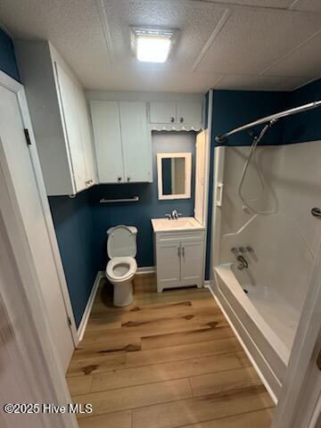 full bathroom featuring hardwood / wood-style floors, vanity, a textured ceiling, bathtub / shower combination, and toilet