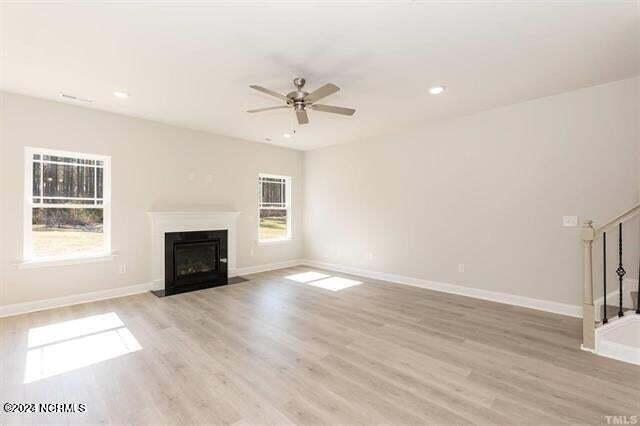 unfurnished living room featuring ceiling fan, light hardwood / wood-style flooring, and a healthy amount of sunlight