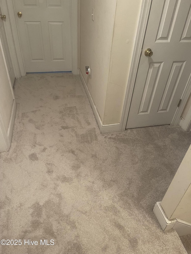 hallway with baseboards and carpet floors